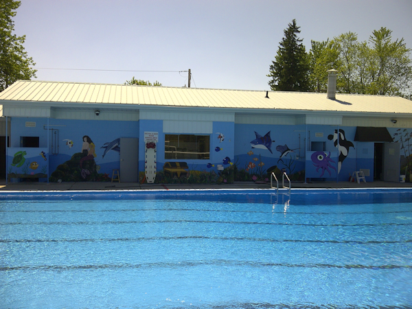 Thamesford pool with bulding behind and mural of fish and whales painted on side of bulding
