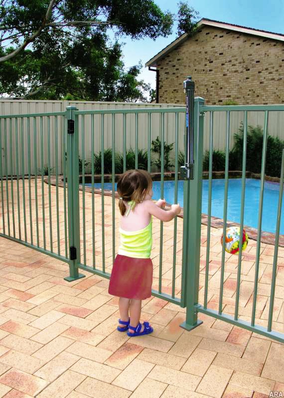 child next to a pool fence